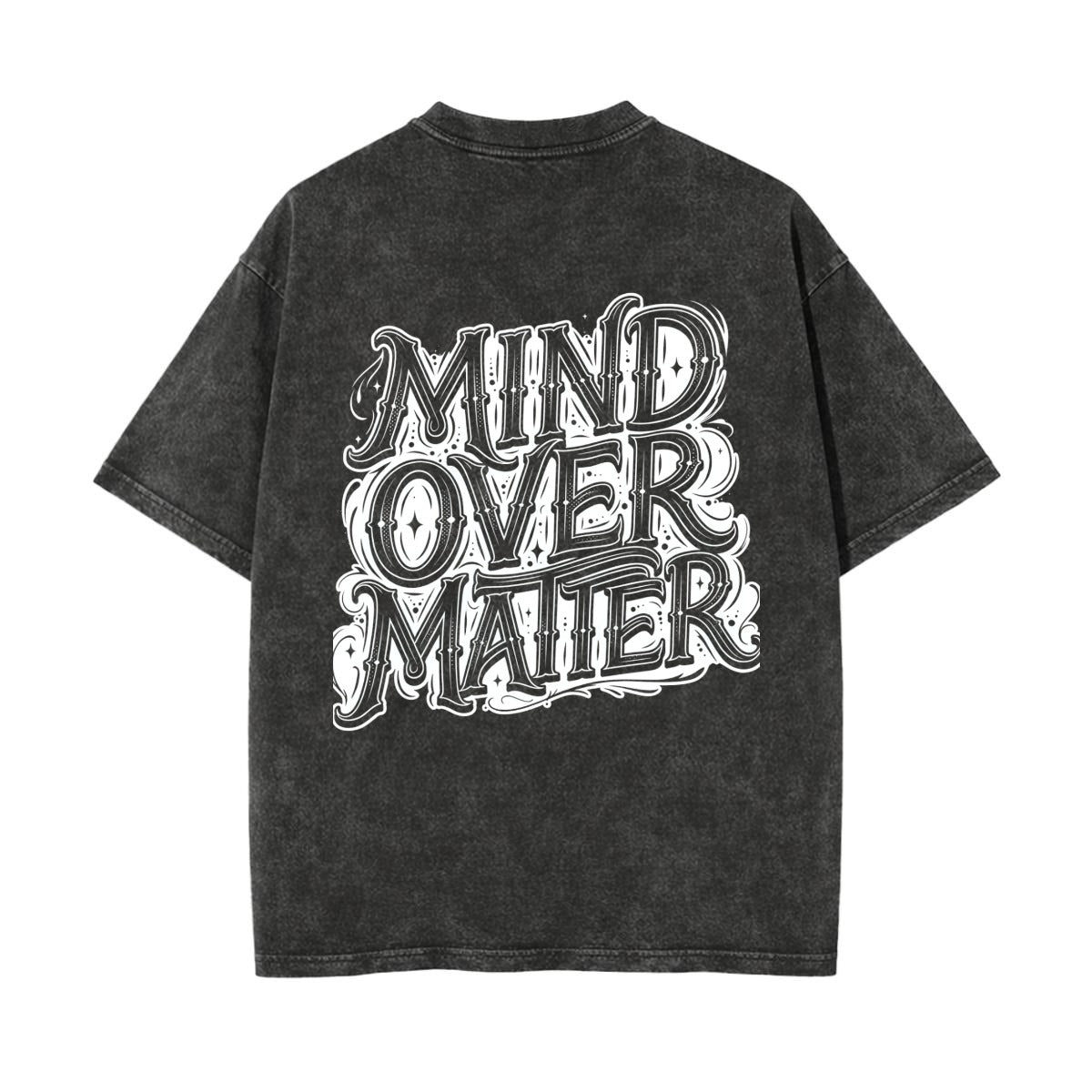 A washed black short-sleeve t-shirt with a large white graphic text print reading 'MIND OVER MATTER' on the back, shown against a plain white background.