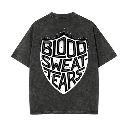 A dark gray mineral-wash t-shirt shown from the back, featuring a large white graphic of a shield with the words 'BLOOD SWEAT TEARS' in stylized lettering.