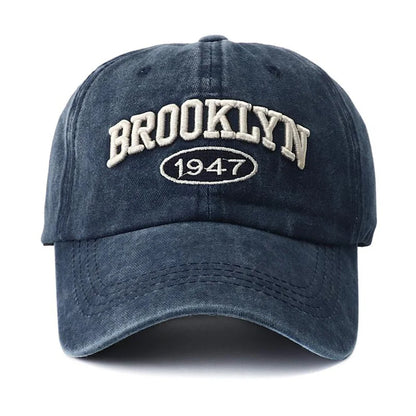 Blue embroidery cap with 'Brooklyn 1947' text on a white background