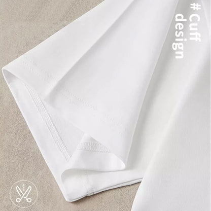 Close-up of white plain t shirt with a visible cuff on a beige surface, featuring the hashtag #CuffDesign.
