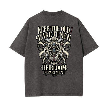 A dark gray acid-wash t-shirt shown from the back, featuring a large graphic print with the text 'KEEP THE OLD MAKE IT NEW' and 'HEIRLOOM DEPARTMENT' surrounding an ornate crest.