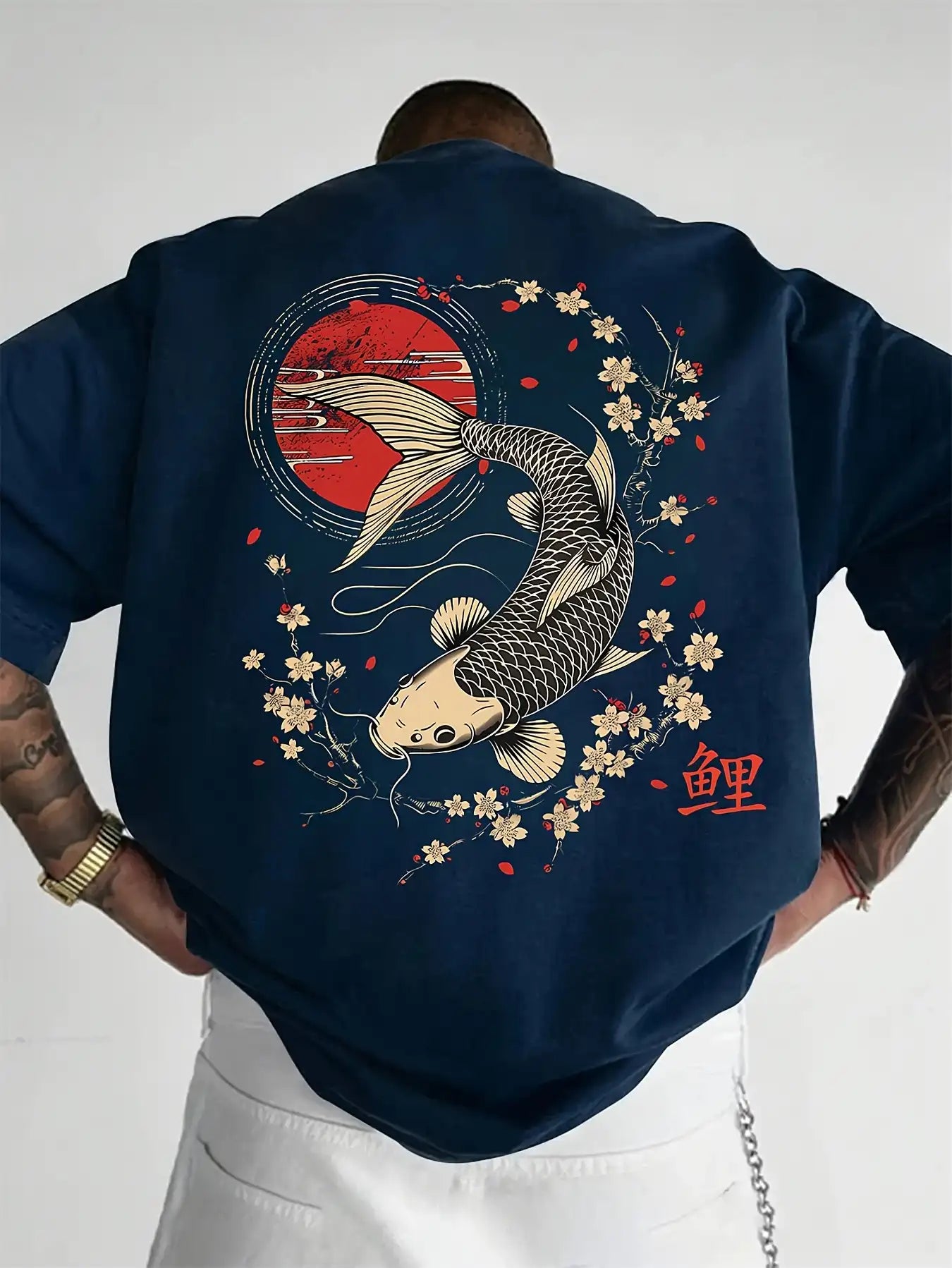 Person wearing a navy blue koi fish oversized t shirt with a koi fish design on the back