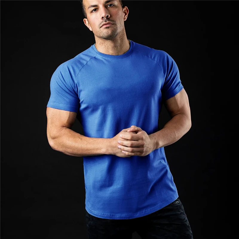 Man wearing a blank blue plain t shirt against a black background