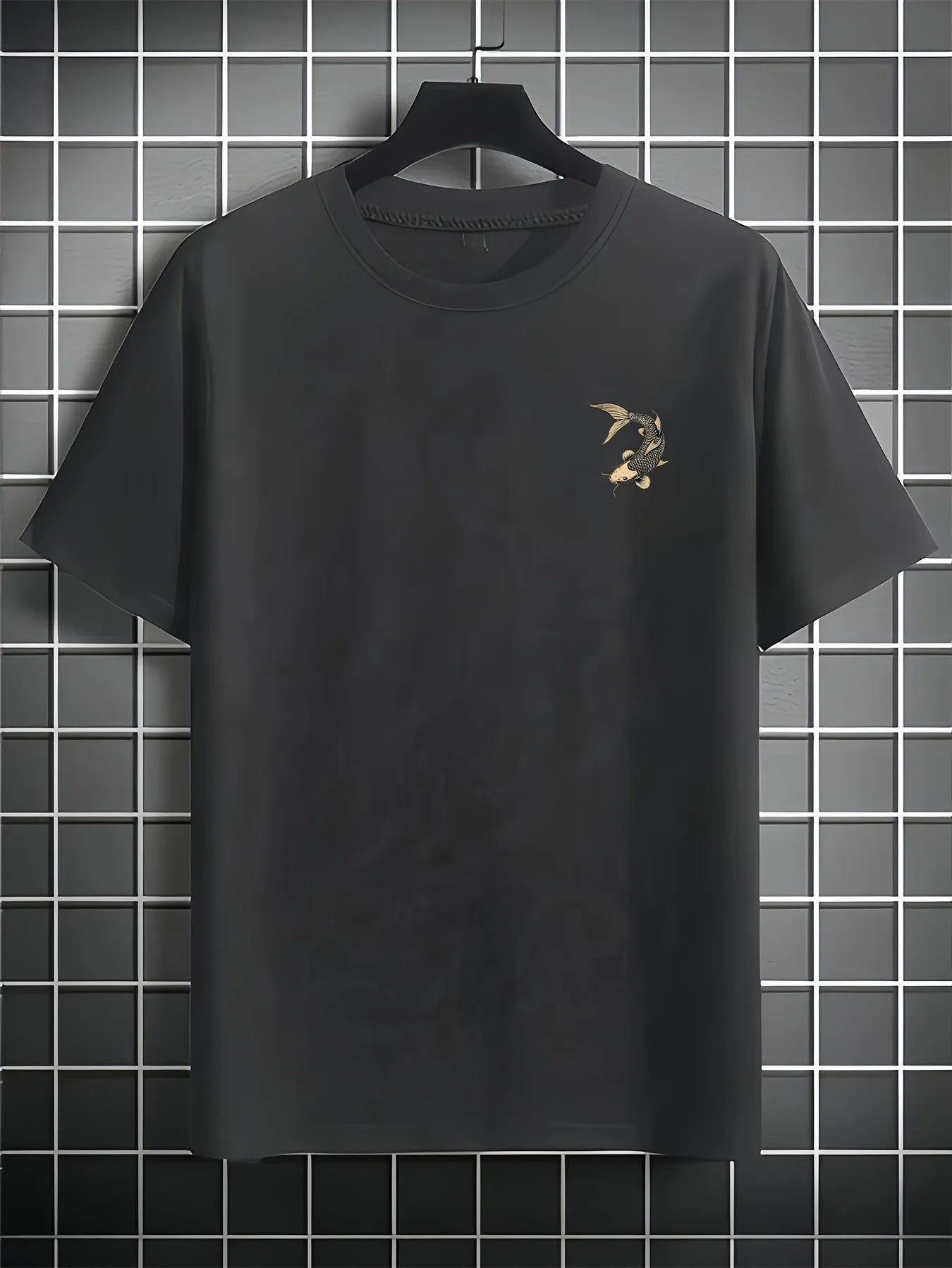 Black koi fish t shirt with a small design on a hanger against a tiled wall.