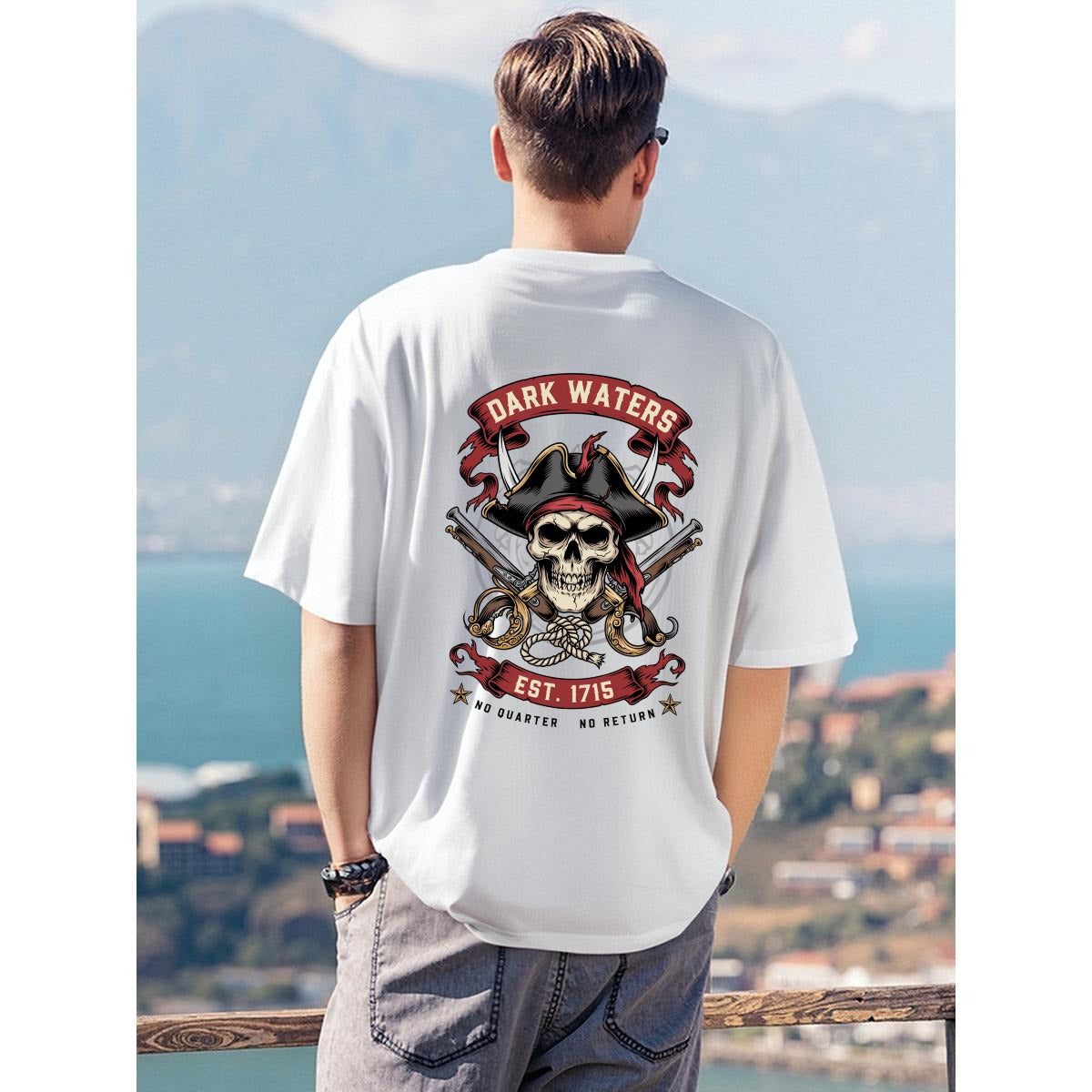 A man viewed from behind wearing a white t-shirt with a large pirate skull graphic on the back. The graphic features the text 'DARK WATERS EST.