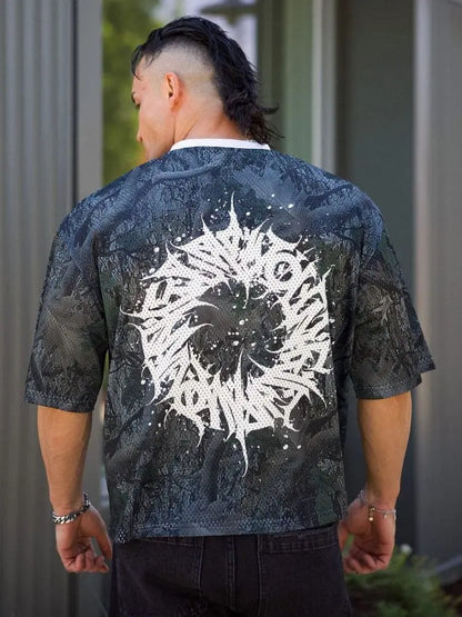 Person wearing a oversized mens graphic tee showing bold maelstrom design on the back, standing outdoors.