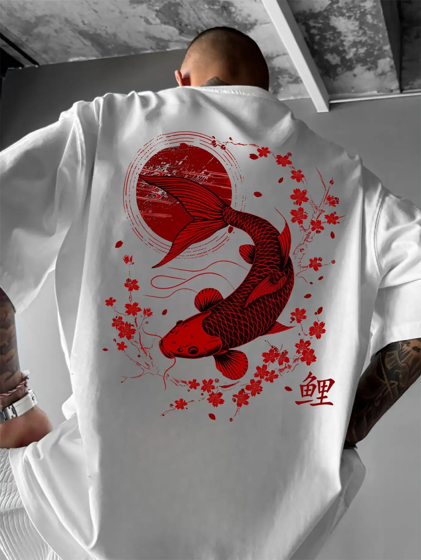 Person wearing a white koi fish oversized t shirt with a red koi fish and cherry blossom design on the back.